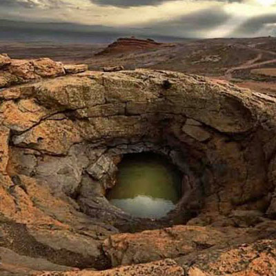نمایی از آب سبز رنگ بزرگترین چشمهی مجموعهی چشمه گرآب که روی تپهای به ارتفاع 30 متر قرار دارد.